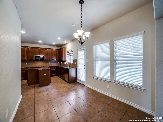 a large kitchen with kitchen island granite countertop a stove a sink and a cabinets