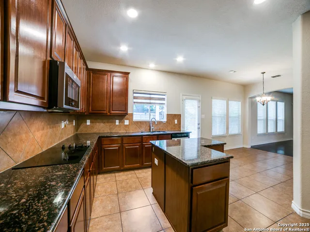 a kitchen with granite countertop stainless steel appliances a counter space and a sink