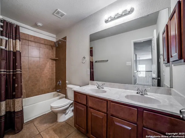 a bathroom with a double vanity sink toilet mirror and shower