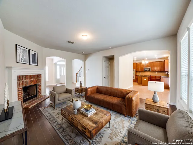 a living room with furniture fireplace and a large window