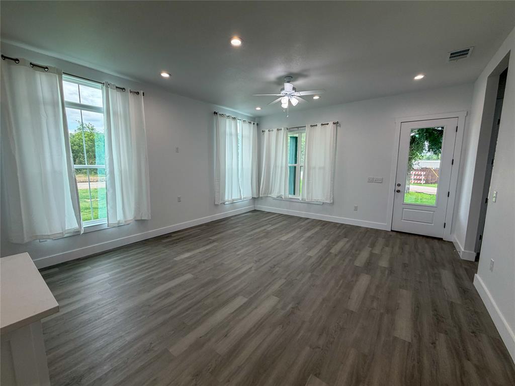 4200 Williams Road Bellmead, TX 76705 - Photo 4 of 22 an empty room with wooden floor and windows