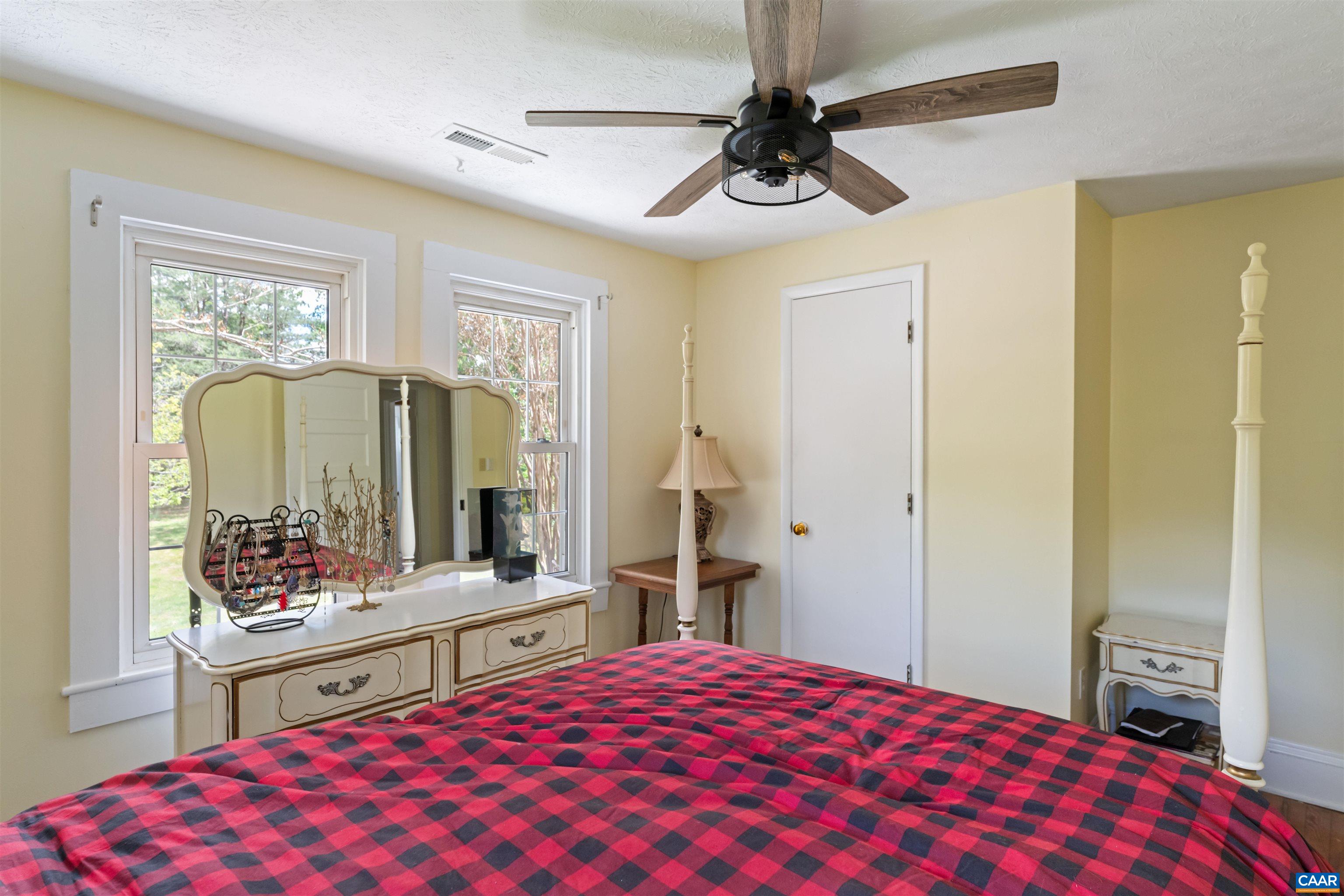418 James River Road Scottsville, VA 24590 - Photo 30 of 61 a bedroom with a bed and a large mirror with a flat tv screen