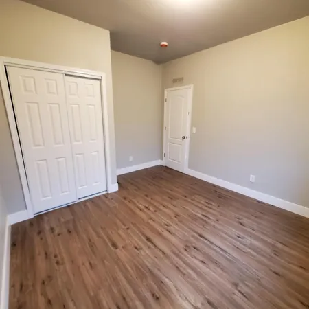 a view of an empty room with wooden floor