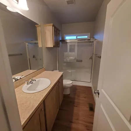 a bathroom with a sink a toilet and shower