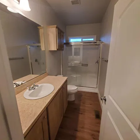 a bathroom with a sink a toilet and shower