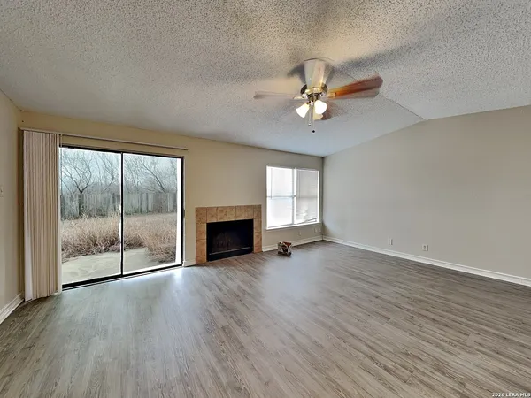 wooden floor fireplace and windows in an empty room
