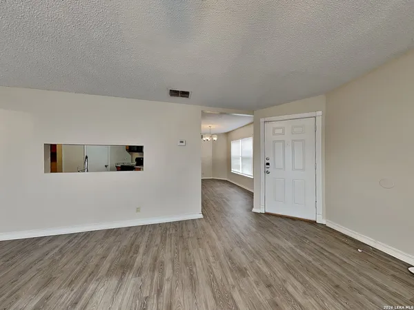 a view of an empty room with wooden floor and closet