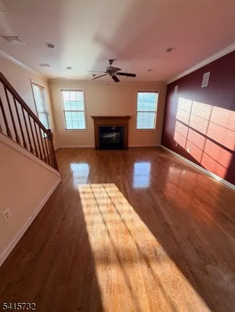 a view of empty room with wooden floor and fireplace