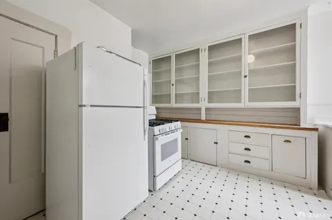 a kitchen with a stove a refrigerator and a window