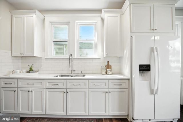 a kitchen with white cabinets and sink