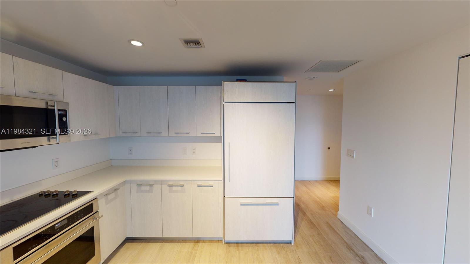 a kitchen with white cabinets and appliances
