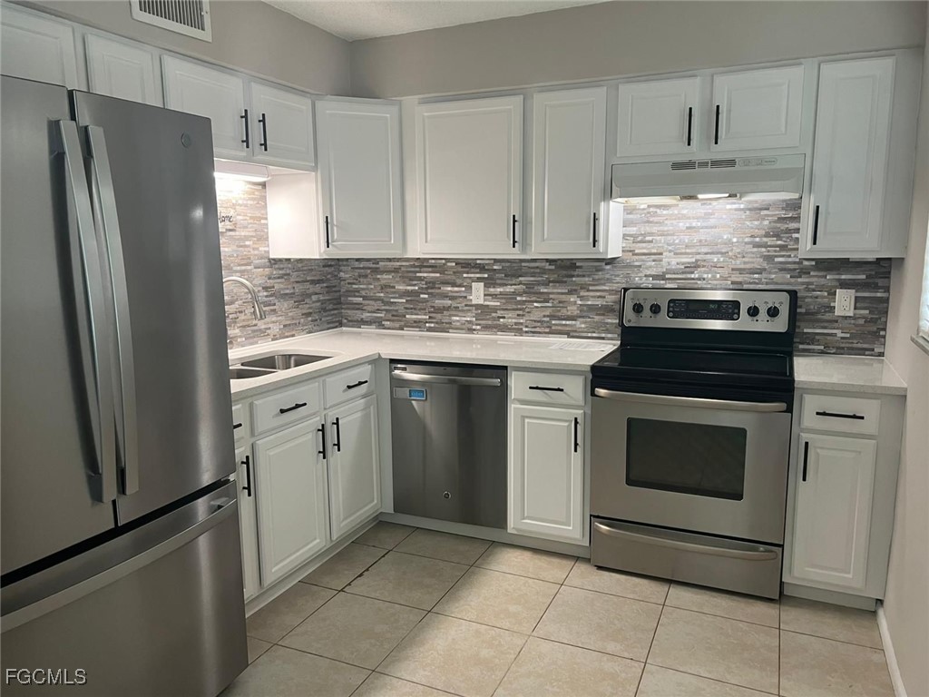 3325 Airport Road North, Unit L2 Naples, FL 34105 - Photo 4 of 14 a kitchen with granite countertop white cabinets and stainless steel appliances
