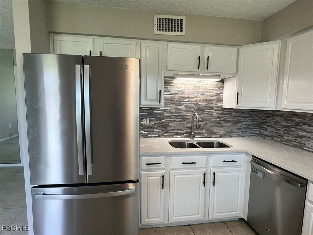 3325 Airport Road North, Unit L2 Naples, FL 34105 - Photo 7 of 14 a kitchen with appliances a refrigerator and cabinets