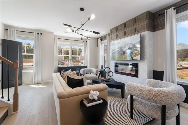 a living room with furniture a large window and a flat screen tv