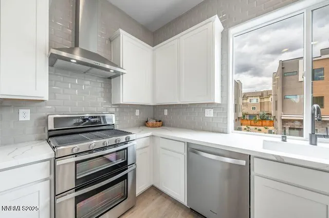 a kitchen with stainless steel appliances white cabinets and a stove top oven