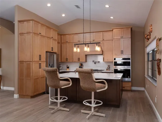 a kitchen with stainless steel appliances granite countertop a sink refrigerator and microwave