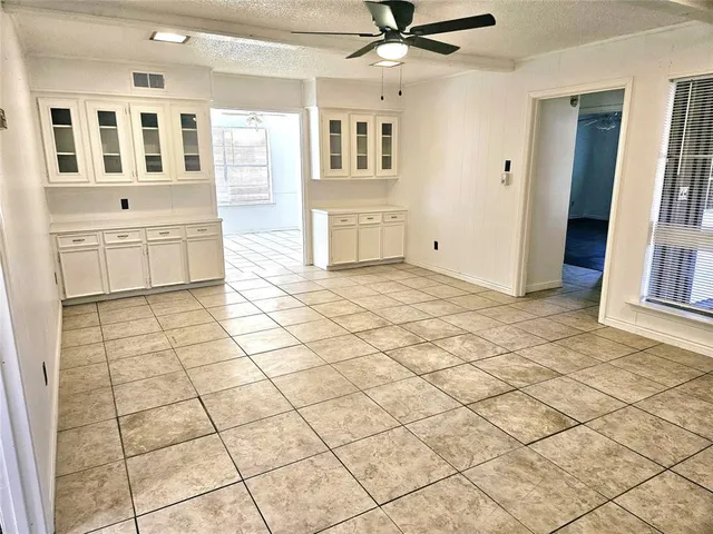 a view of a livingroom with kitchen appliances and cabinets