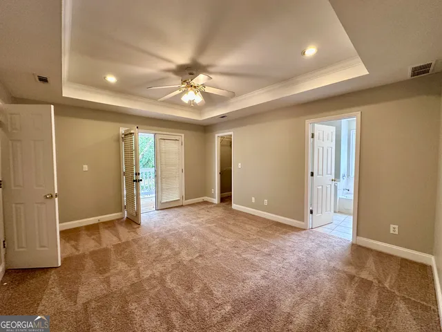 an empty room with fan and entryway