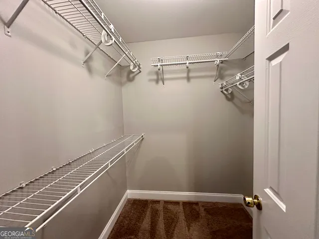an empty room with closet and a chandelier fan