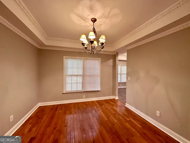a view of a big room with wooden floor and windows