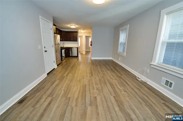 a view of a room with wooden floor and windows