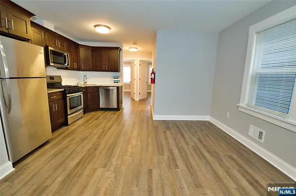 a kitchen with stainless steel appliances wooden floors and wooden cabinets