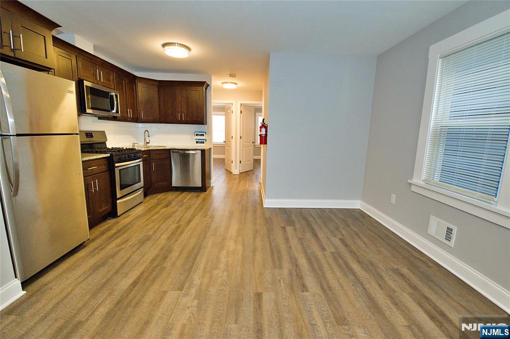 116 Maple Avenue, Unit 4 Montclair, NJ 07042 - Photo 5 of 14 a kitchen with stainless steel appliances wooden floors and wooden cabinets