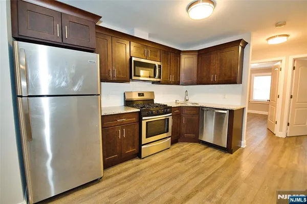 a kitchen with stainless steel appliances a refrigerator a stove a sink a microwave and cabinets