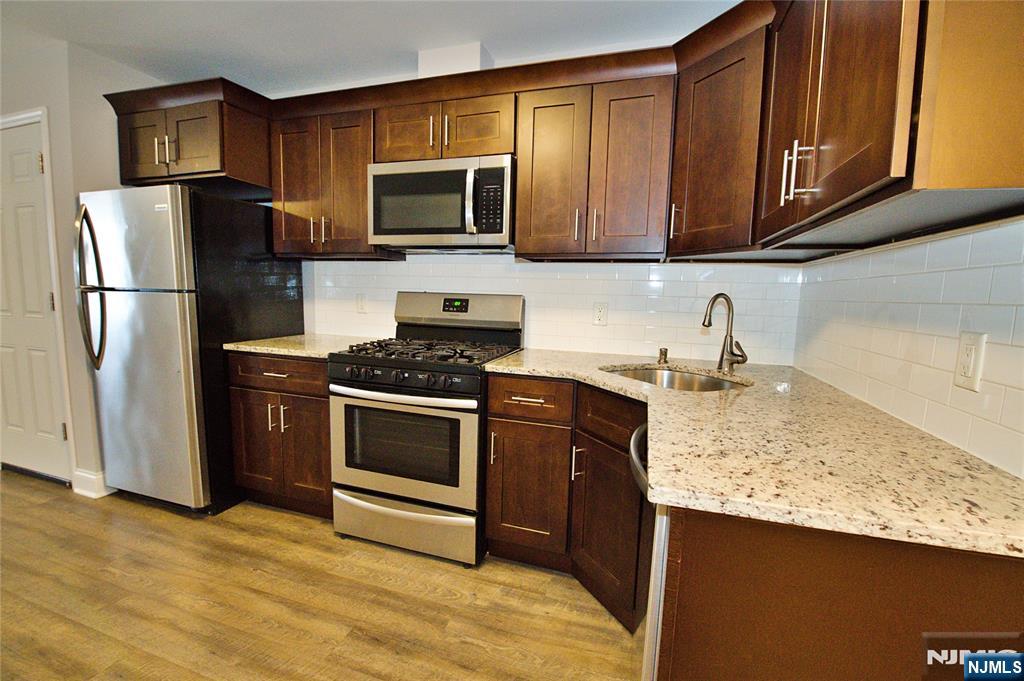 116 Maple Avenue, Unit 4 Montclair, NJ 07042 - Photo 7 of 14 a kitchen with stainless steel appliances granite countertop a refrigerator stove top oven a sink and dishwasher