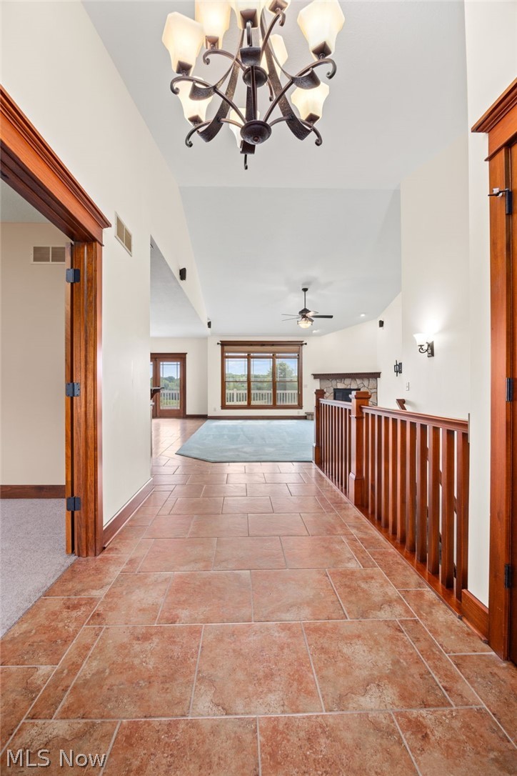6925 River Styx Road Medina, OH 44256 - Photo 3 of 49 Entryway featuring large format tile flooring, a decorative chandelier, and wood-finish trim
