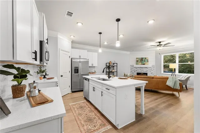 a kitchen that has a lot of white cabinets and couches