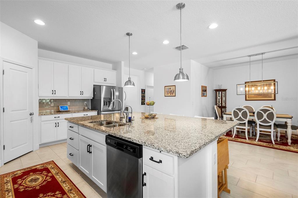 744 Hyperion Drive DeBary, FL 32713 - Photo 12 of 54 a kitchen with stainless steel appliances granite countertop a sink stove and refrigerator