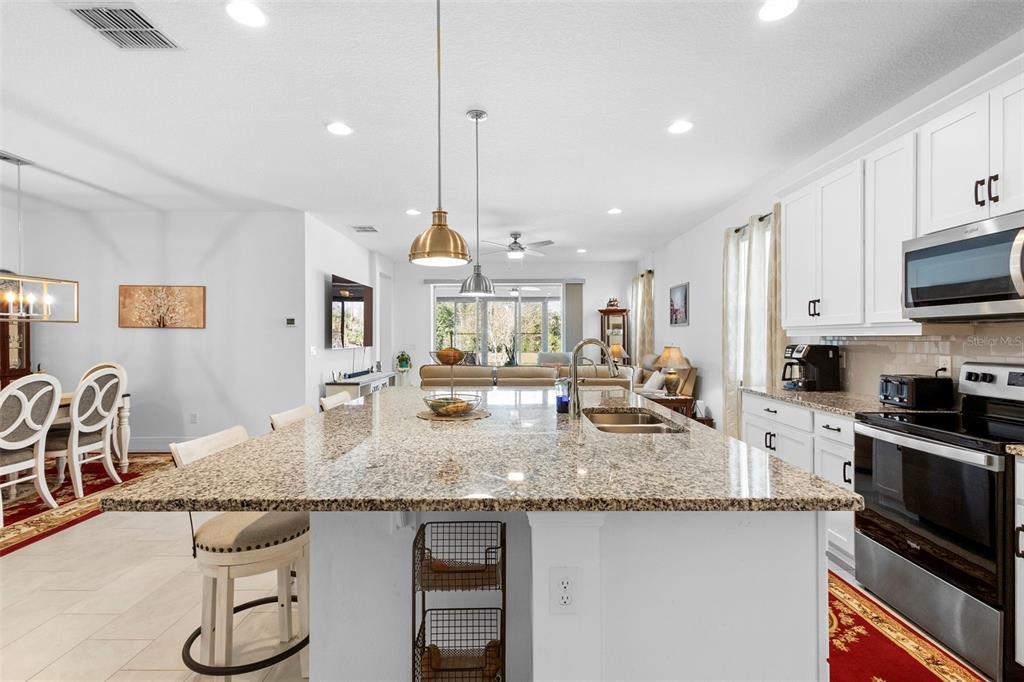 744 Hyperion Drive DeBary, FL 32713 - Photo 14 of 54 a kitchen with stainless steel appliances granite countertop a sink stove and refrigerator