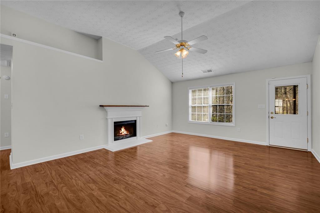 201 Wisteria Way Athens, GA 30606 - Photo 6 of 38 a view of an empty room with wooden floor fireplace and a window