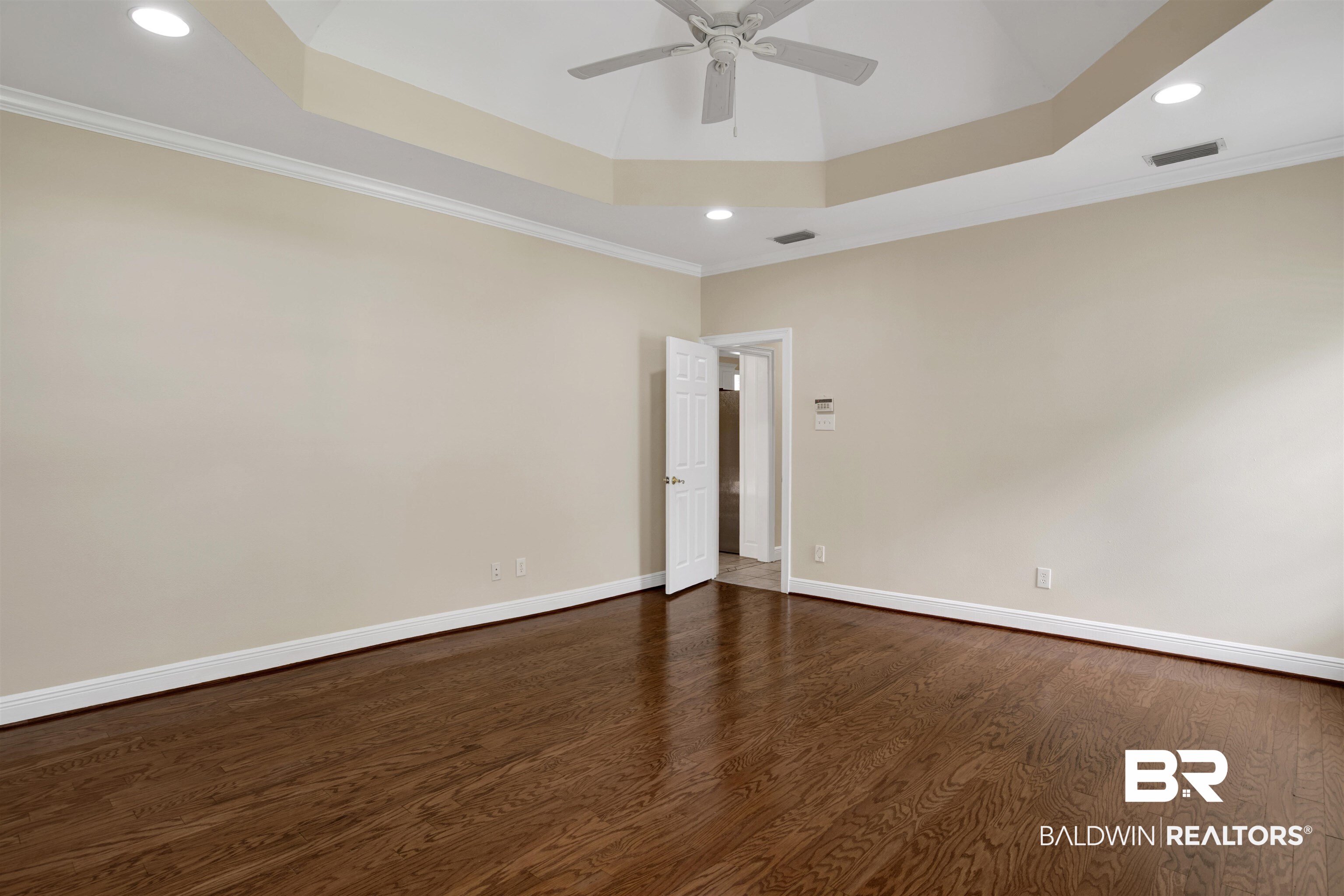 8847 Dawes Lake Road South Mobile, AL 36619 - Photo 25 of 47 Spacious room featuring rich wood-finish flooring, a tray ceiling with recessed lighting, crown molding, and a ceiling fan