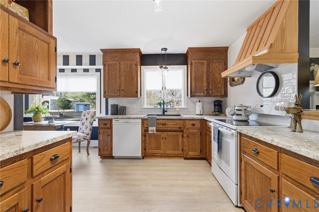 6606 West Quaker Road Disputanta, VA 23842 - Photo 13 of 32 Kitchen with white appliances, brown cabinetry, cu