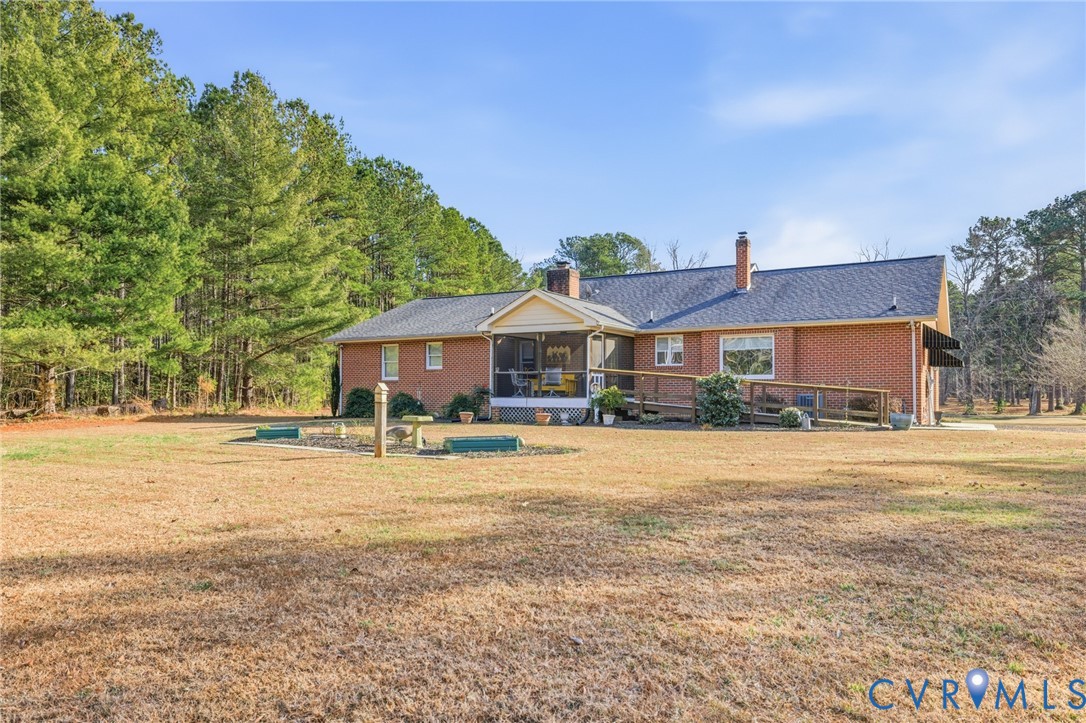 6606 West Quaker Road Disputanta, VA 23842 - Photo 31 of 32 Rear view of house featuring a sunroom, brick sidi