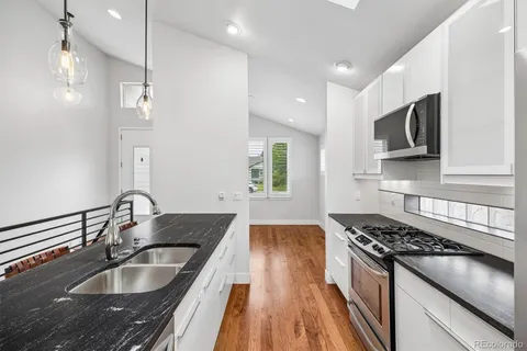 a kitchen with granite countertop a sink and a stove top oven