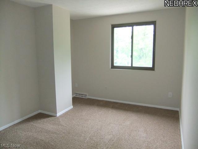 992 Hampton Ridge Drive Akron, OH 44313 - Photo 14 of 17 Newer neutral carpet and paint flow througout this level. Shown here bedroom 2 with a double closet.