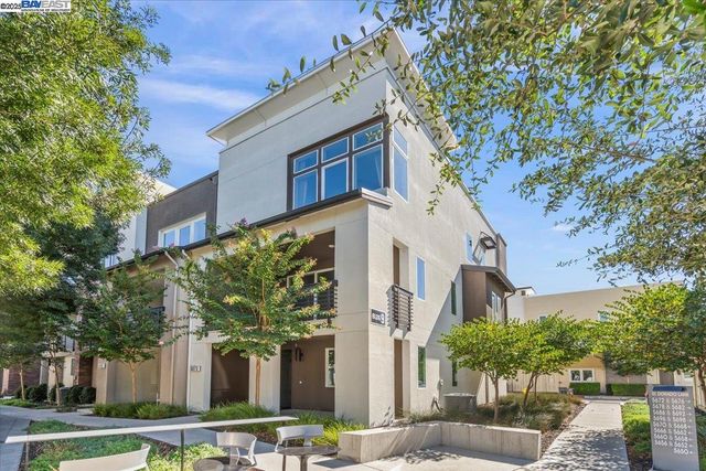 a view of a building with a yard and plants