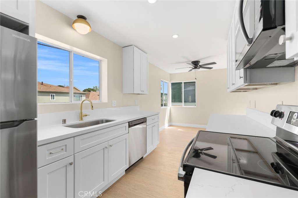 3020 East 3rd Street Long Beach, CA 90814 - Photo 27 of 63 a kitchen with a sink wooden floor and a stove top oven