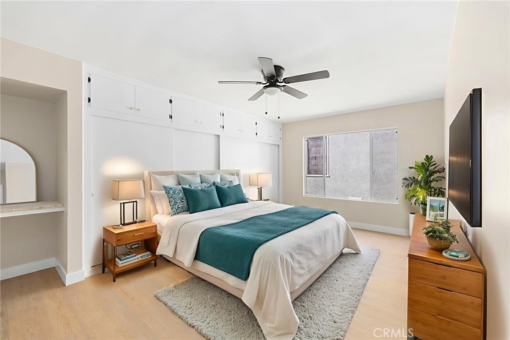 3020 East 3rd Street Long Beach, CA 90814 - Photo 10 of 63 a bedroom with a bed a mirror on dresser and a chandelier