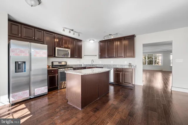 a kitchen with granite countertop a stove a sink and a refrigerator