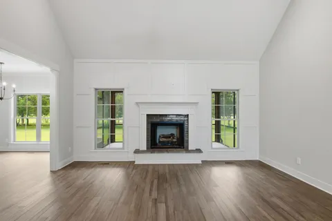 an empty room with a fireplace and windows