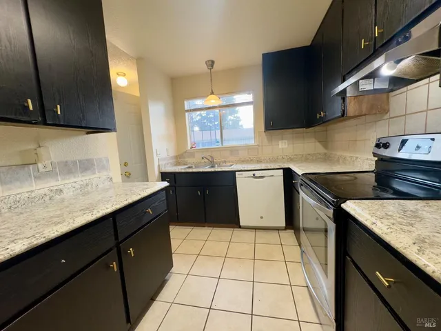 a kitchen with a sink stove top oven and cabinets