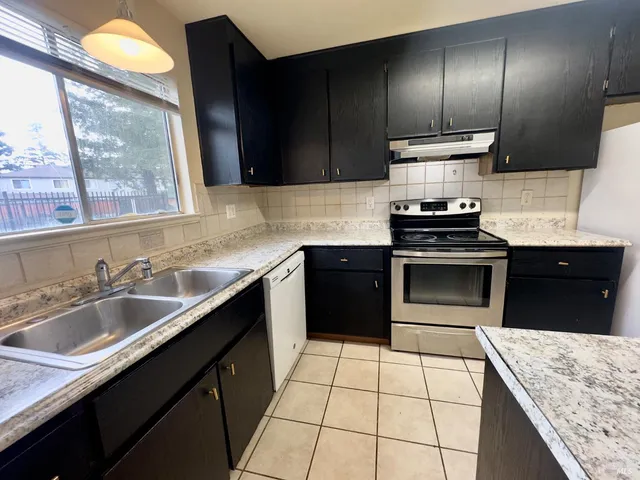 a kitchen with stainless steel appliances granite countertop a sink stove and cabinets