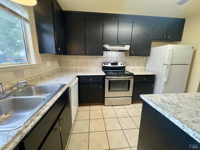 a kitchen with a sink stove and refrigerator