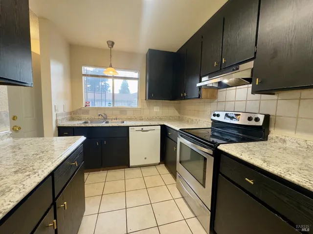 a kitchen with a sink stove and cabinets