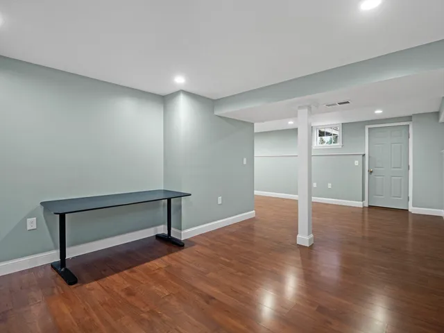 a view of an empty room with wooden floor
