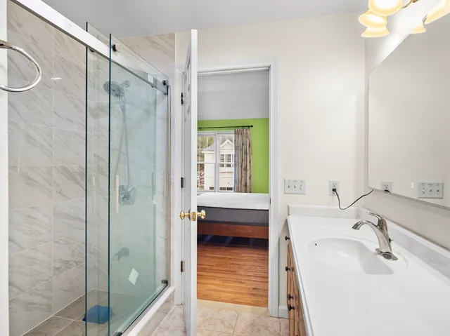 a bathroom with a sink a toilet a shower and a mirror